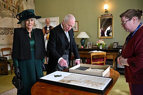Britain's King Charles III and Britain's Queen Camilla look at a display of the Cathedral’s Magna Cartas after attending the Royal Maundy Service at Durham Cathedral on April 17, 2025 in Durham, England.