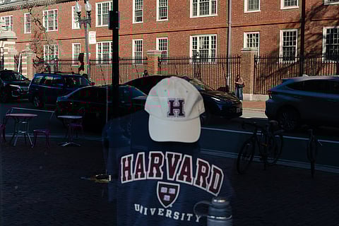 Harvard University is reflected in the window of a merchandise store across the street from the school on April 17, 2025 in Cambridge, Massachusetts.
