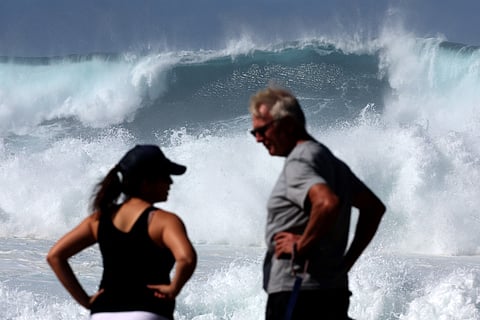 Visitors watch large waves crash against a rock on Bronte Beach in Sydney on April 18, 2025, amid powerful swells hitting Australia’s east coast.