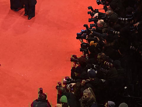 An illustrative image of the press gathered on a red carpet to capture images