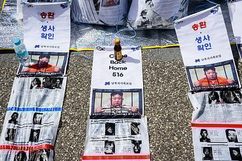Pictures depicting North Korean leader Kim Jong Un are seen with anti-North Korea propaganda leaflets attached to bags at the Imjingak Pavilion near the Demilitarized Zone (DMZ) dividing the two Koreas in Paju, north of Seoul on April 23, 2025, as members of the Association of the Families of Those Abducted by North Korea prepare to send them across the border.