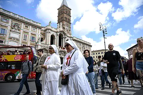 Nuns walk past Santa Maria Maggiore Basilica, where the Pope will be buried after his funeral.