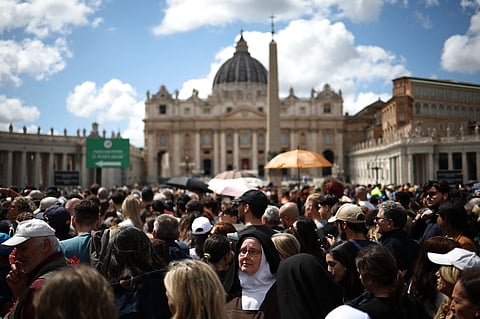 A nun (C) looks on as she queues to pay her respects to late Pope Francis, with a view of the Vatican's St Peter's Basilica, a day prior to the late Pope's funeral, in Rome on April 25, 2025.