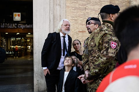 WikiLeaks founder Julian Assange (L) speaks with a member of the military forces in Via della Conciliazione by St Peter's Square in The Vatican on April 26, 2025 during late Pope Francis' funeral ceremony.