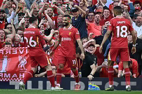 Liverpool's Egyptian striker #11 Mohamed Salah (C) celebrates with teammates after scoring their fourth goal during the English Premier League football match between Liverpool and Tottenham Hotspur at Anfield in Liverpool, north west England on April 27, 2025.