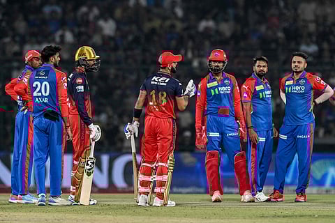 Royal Challengers Bengaluru's Virat Kohli (C) speaks with Delhi Capitals' players as they wait for the result of the Decision Review System (DRS) during the Indian Premier League (IPL) Twenty20 cricket match between Delhi Capitals and Royal Challengers Bengaluru at the Arun Jaitley Stadium in New Delhi on April 27, 2025.