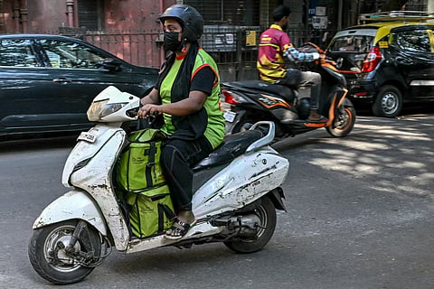 A rider leaves with customers' orders for delivery after collecting from a BigBasket dark store in Mumbai.
