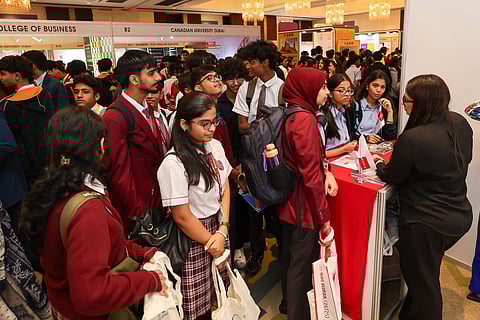 High school students interacting with university representatives at Edufair