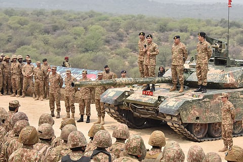 This handout photograph taken on May 1, 2025 and released by the Pakistan's Inter Service Public Relation (ISPR) shows Pakistan's Army Chief General Syed Asim Munir (Top 3R) standS on military tank speaks with army troops to witness exercise 'Hammer Strike' a high-intensity field training exercise conducted by Pakistan Army’s Mangla Strike Corps at the Tilla Field Firing Ranges (TFFR) in Jhelum, Punjab province.