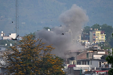 Smoke billows after an artillery shell landed in the main town of Poonch district in India's Jammu region on May 7.