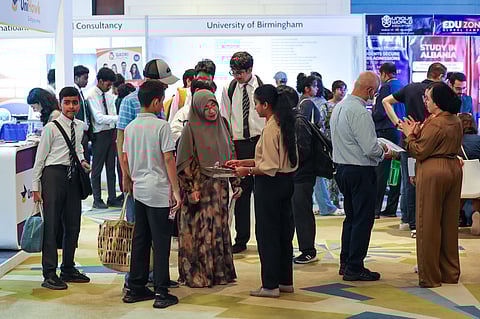 Families interacting with university representatives at Edufair