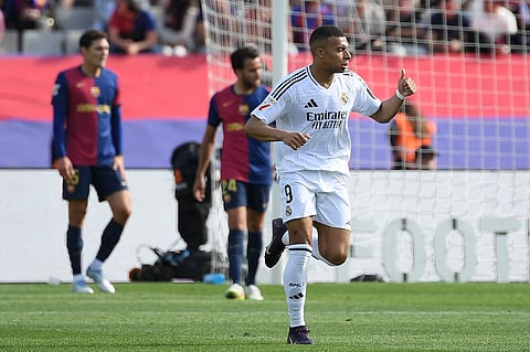 Real Madrid's French forward Kylian Mbappe celebrates scoring his hat-trick during the Spanish league football match against FC Barcelona at Estadi Olimpic Lluis Companys in Barcelona, on May 11.