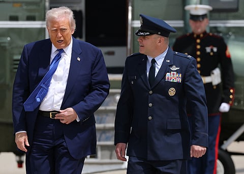 Trump walks with Air Force Col. Paul R. Pawluk as he arrives to board Air Force One on May 12, 2025, at Joint Base Andrews, Maryland.
