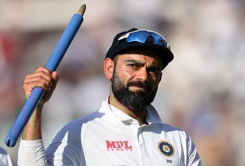 India's captain Virat Kohli holds aloft a stump as he leaves the field after India won the fourth Test against England at the Oval.