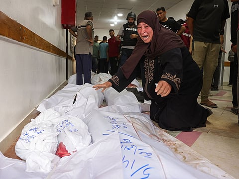 A Palestinian woman mourns over the bodies of people killed in Israeli strikes on Jabalia, at the Indonesian Hospital in Beit Lahia in the northern Gaza Strip on May 14, 2025.