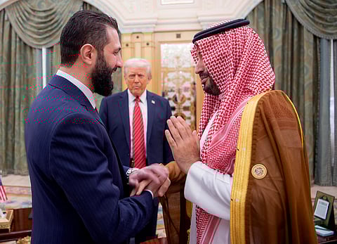 Saudi Crown Prince Mohammed bin Salman greeting Syria's interim president Ahmed Al Sharaa as US President Donald Trump looks on, in Riyadh on May 14, 2025.