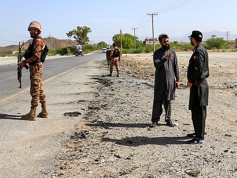 Security personnel stand guard at the site of a school bus bombing in Khuzdar district of Balochistan province on May 21, 2025.