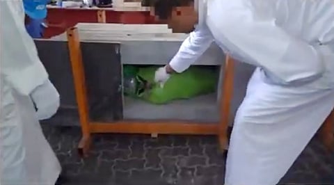 A customs official examines hashish that had been secretly hidden inside marble slabs in a shipment arriving at Kuwait's Shuwaikh Port earlier this month.