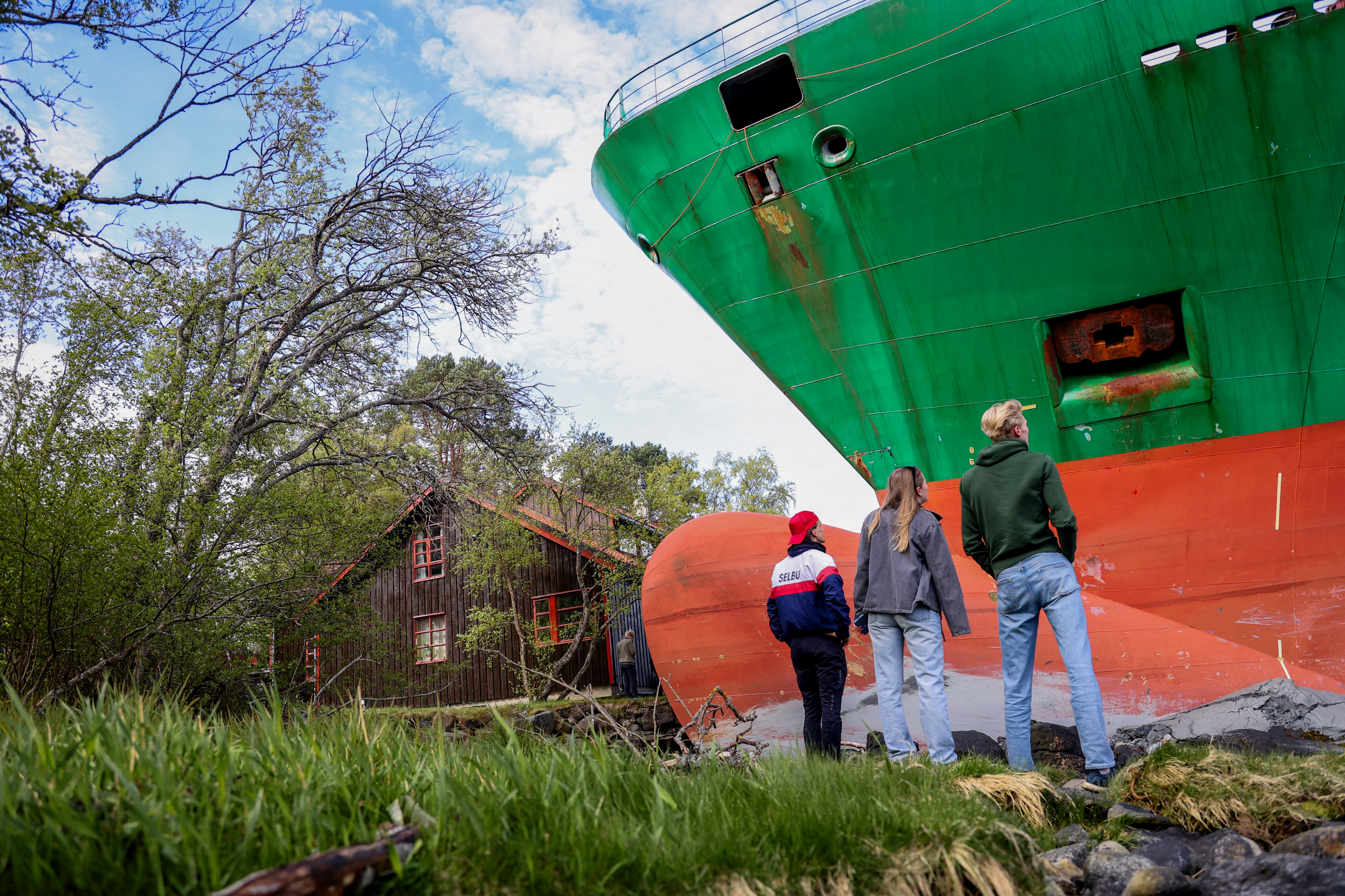 meter-long container ship is pictured by the shore as bystanders watch after it ran aground.
