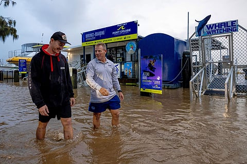 Conor Lang and Anthony Heeney walk through flooded areas in Port Macquarie, north of Sydney, Australia, Wednesday, May 21.