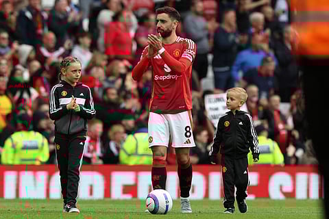 Manchester United's Bruno Fernandes and his children during the lap of honour after the English Premier League match against Aston Villa at Old Trafford on May 25.