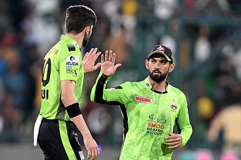 Lahore Qalandars' captain Shaheen Shah Afridi (L) celebrates with Sikandar Raza after taking the wicket of Quetta Gladiators' Hasan Nawaz during the Pakistan Super League (PSL) Twenty20 final cricket match between Lahore Qalandars and Quetta Gladiators at the Gaddafi Stadium in Lahore on May 25, 2025.