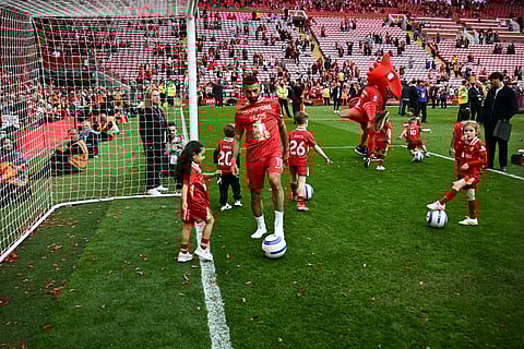Liverpool's Egyptian striker Mohamed Salah plays football as he celebrates with his relatives after winning the Premier League trophy on Sunday.