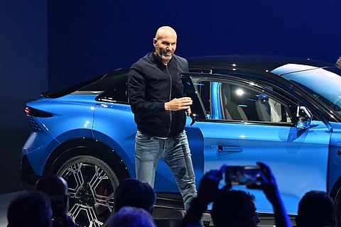French football legend and coach Zinedine Zidane poses next to the Alpine A390 electric car during its World premiere, in Dieppe, northwestern France, on May 27, 2025.