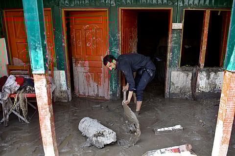 A man shovels mud from his house, a day after flash floods in Balgran village near Muzaffarabad, capital of Pakistan-administered Kashmir on May 28, 2025.