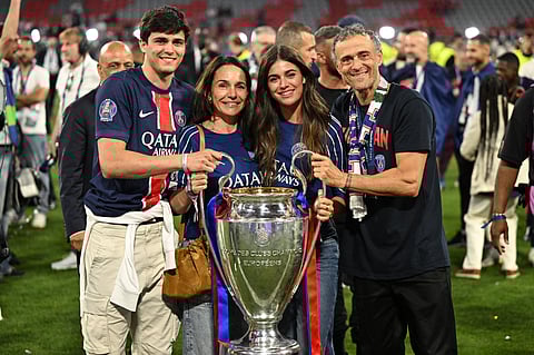 Paris Saint-Germain's headcoach Luis Enrique (right), his wife Elena Cullell (second from left), son Pacho Martinez (left) and daughter Sira Martinez pose with the Champions League trophy in Munich on Saturday night.