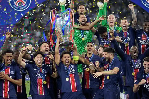 PSG players celebrate with the trophy after winning the Champions League final soccer match between Paris Saint-Germain and Inter Milan at the Allianz Arena in Munich, Germany.