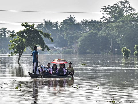 School children return home on a boat after heavy rains at a flood affected area in Kampur at Nagaon district, in India's northeastern state of Assam.