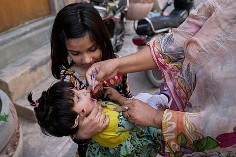 A health worker administers a polio vaccine to a child at a neighbourhood, in Lahore, Pakistan, Monday, May 26, 2025.