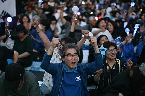 People celebrate after exit polls show South Korea's Lee Jae-myung of the left-leaning Democratic Party appears on track to win the presidential election in Seoul on June 3, 2025.