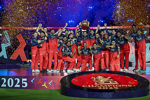 Royal Challengers Bengaluru's players celebrate with the trophy after winning the Indian Premier League (IPL) Twenty20 final cricket match against Punjab Kings at the Narendra Modi Stadium in Ahmedabad on June 4, 2025.