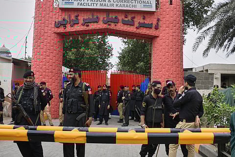 Police officer and paramilitary soldiers stand guard outside the district Malir prison, from where more than 100 inmates escaped overnight, in Karachi on June 3, 2025.