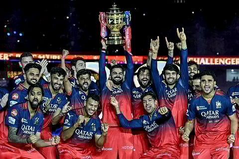 Royal Challengers Bengaluru's Virat Kohli (C), along with his teammates, celebrates with the trophy after winning the Indian Premier League (IPL) Twenty20 final match against Punjab Kings at the Narendra Modi Stadium in Ahmedabad on June 4, 2025.