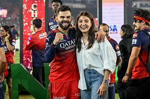 Royal Challengers Bengaluru's Virat Kohli (centre L) celebrates along with his wife and actress Anushka Sharma (centre R) after winning the Indian Premier League (IPL) Twenty20 final cricket match against Punjab Kings