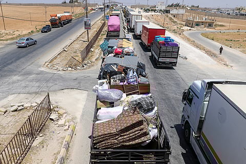 A convoy trucks and buses and provided by "Waqf Farah" foundation carrying more than 700 Syrian refugees and their belongings, moves from the Jordan-Emirati camp in Azraq, east of Amman, on their way back to Syria on June 3, 2025 ahead of the Eid Al Adha holiday.