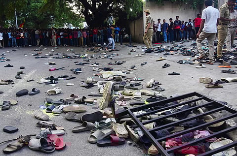 Fans stand next to abandonned shoes and a fallen barrier following a stampede during celebrations, a day after Royal Challengers Bengaluru's victory at the Indian Premier League (IPL) Twenty20 final cricket match, outside the M. Chinnaswamy Stadium in Bengaluru on June 4, 2025.