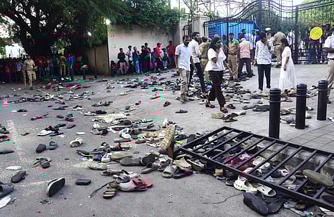 Fans stand next to abandonned shoes and a fallen barrier following a stampede during celebrations, a day after Royal Challengers Bengaluru's victory at the Indian Premier League (IPL) Twenty20 final cricket match, outside the M. Chinnaswamy Stadium in Bengaluru on June 4, 2025.