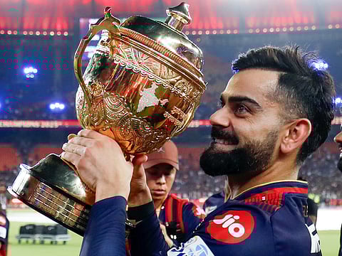 Royal Challengers Bengaluru's Virat Kohli, holding the trophy, goes on a victory lap after the team's win in the Indian Premier League 2025 final against Punjab.