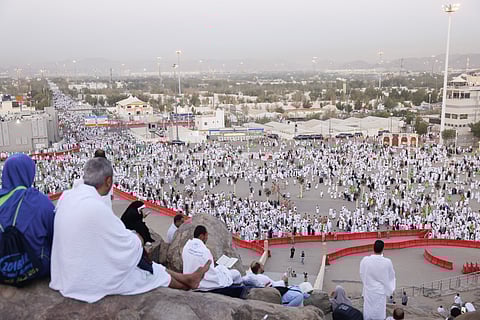 Pilgrims atop Saudi Arabia's Mount Arafat watch others make their way, during the climax of the Hajj pilgrimage on June 5, 2025.