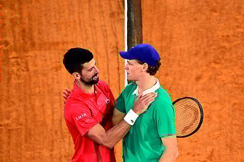 Winner Italy's Jannik Sinner cheers Serbia's Novak Djokovic (L) at the end of their men's singles semi-final match on day 13 of the French Open tennis tournament on Court Philippe-Chatrier at the Roland-Garros Complex in Paris on June 6, 2025.