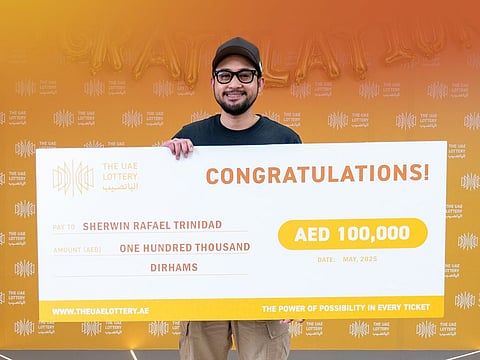 Sherwin Rafael Trinidad with his ceremonial cheque for Dh100,000.