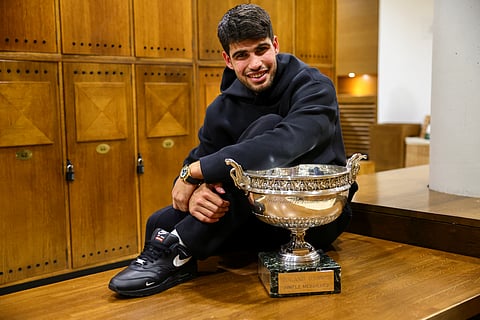 Spain's Carlos Alcaraz poses with the trophy in the locker room, after victory in the men's singles final match against Italy's Jannik Sinner on day 15 of the French Open tennis tournament at the Roland-Garros Complex in Paris on June 8, 2025.