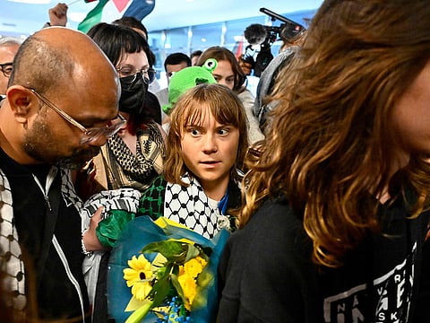 Swedish campaigner Greta Thunberg (C) looks on as she is greeted on arrival at Stockholm-Arlanda airport, on the outskirts of Stockholm.