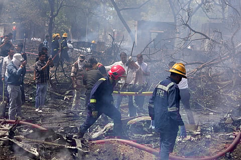 Firefighters work at the crash site of an airplane in Ahmedabad, Gujarat, India,