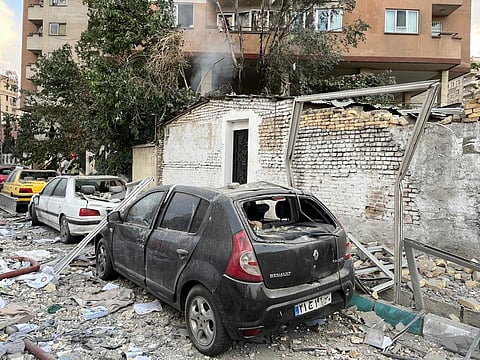 Debris from an apartment building is seen on top of parked cars after a strike in Tehran, Iran, early Friday, June 13, 2025.