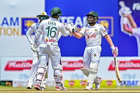 Bangladesh's Mushfiqur Rahim (R) celebrates with Litton Das after scoring 150 runs during the second day of the first Test cricket match against Sri Lanka at the Galle International Cricket Stadium in Galle on June 18, 2025.